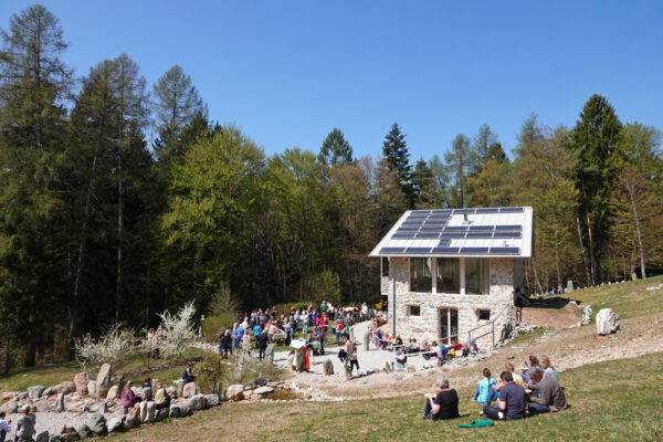 Die Sonnenoase in Lundo am Gardasee mit Seminarhaus und Teilnehmern auf der Waldlichtung